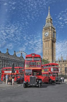 three red double decker buses parked in front of big ben