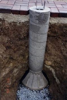 a cement pillar sitting on top of a pile of dirt