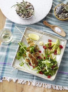 a plate filled with food on top of a table next to two bowls and spoons