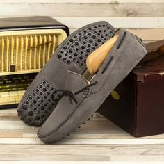 a pair of gray shoes sitting on top of a wooden table next to an old radio