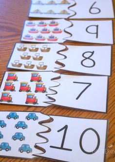 three numbered numbers with cars on them sitting on top of a wooden table next to each other