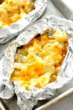 two foil packets filled with food sitting on top of a table