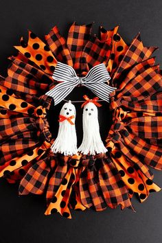 a wreath with two ghost decorations on it