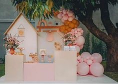 there are balloons and decorations in front of a house on the ground with trees behind it