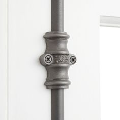 an iron door handle on the side of a white door