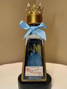 a small bottle with a tiara on top of it