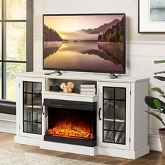 a flat screen tv sitting on top of a white entertainment center next to a fire place