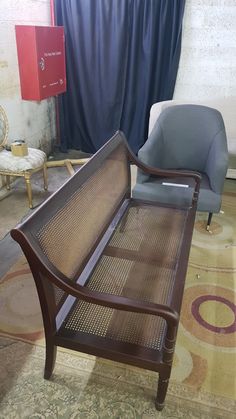 a wooden bench sitting on top of a carpeted floor next to a blue chair