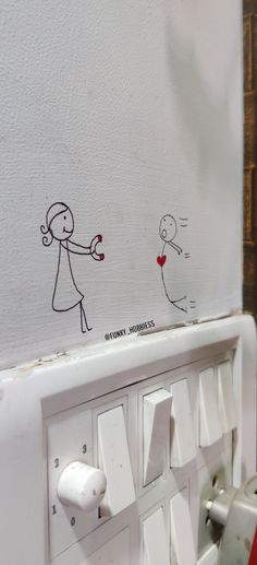 a white wall with stickers on it and a drawing of a person holding a heart