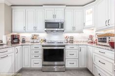 a kitchen with white cabinets and stainless steel appliances