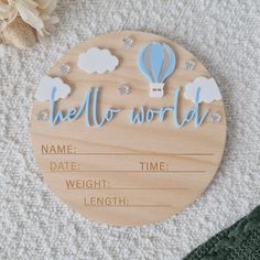 a wooden sign that says hello world with hot air balloon in the sky and stars