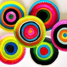 colorful paper plates are stacked on top of each other in the shape of an abstract design