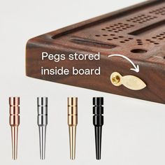 the pegs stored inside the wooden board are different colors and sizes, including gold