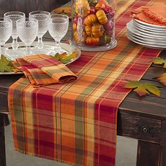 the table is set with plates, glasses and silverware for an elegant fall dinner