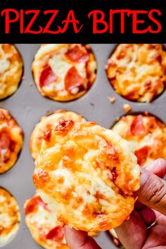 a person holding up a small pizza in front of some muffins on a pan