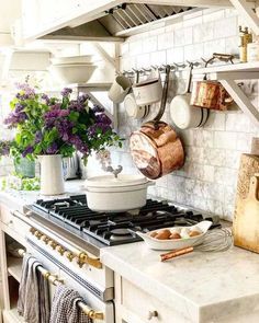 a stove top oven sitting inside of a kitchen next to a pot and pans