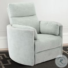 a light blue recliner chair sitting on top of a black rug in front of a white wall