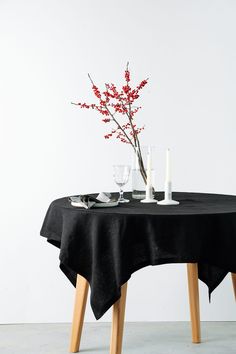 a black table cloth with flowers and candles on it