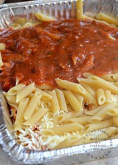 a pan filled with pasta and sauce on top of a table