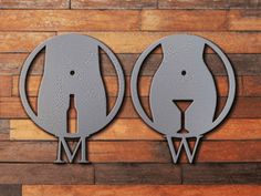 two metal elephants are mounted to the side of a wooden wall