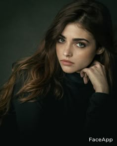 a woman with long brown hair and blue eyes is posing for a photo in front of a black background