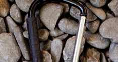 a black umbrella laying on top of rocks next to a pile of stones and pebbles