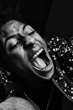 a woman with her mouth open and tongue out in front of the camera while wearing a polka dot shirt