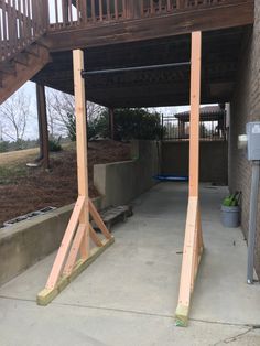 two wooden poles are standing in front of a building with stairs and railings on either side