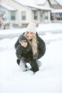 a woman and child playing in the snow