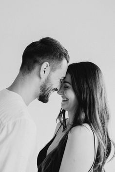 black and white photograph of a man and woman smiling at each other with their foreheads close together