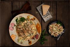 a plate with pasta, meat and vegetables on it next to a basket of bread