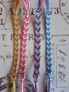 three different colored braided bracelets on top of a table