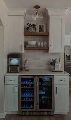 a kitchen with two wine coolers in the center and open shelves on the wall