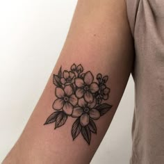 a black and white flower tattoo on the right arm, with leaves around it's edges