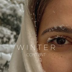 a woman with snow all over her face and eyebrows, looking at the camera while she is covered in white fabric