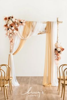 a wedding arch decorated with flowers and white drapes