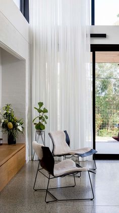 a living room filled with furniture and a white curtain hanging from the side of it