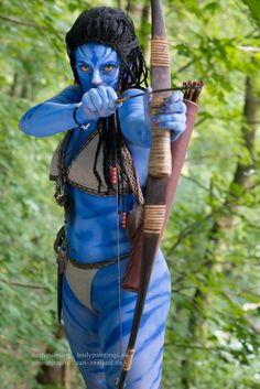 a man dressed as avatar holding a bow and arrow