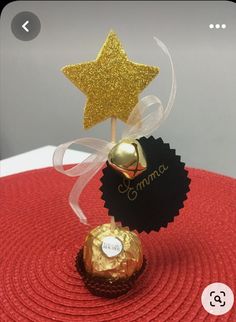 a small gold star on top of a candy bar with a name tag attached to it