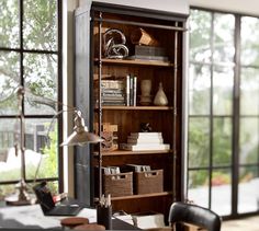 an open bookcase in the corner of a room with lots of books on it