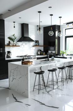 a kitchen with marble counter tops and stools next to an island in the middle