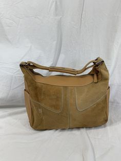 "Measurements are 14\" top wide, 9\"5 high, 5\" deep with one 13\" shoulder strap with a 5\" drop. This bag is adorned with one main compartment, back zipper pocket, lined in brown fabric and a top zipper closure. The leather is nice and strong with no tears and there is minor balding on calf hair. Bag has all working zippers, 4 exterior pockets, light stitching and bag is spacious. Made in Italy with serial# L8 07 and is 100% genuine Tod's. -----------------------------------------I SHIP WORLDW Designer Suede Shoulder Bag With Detachable Strap, Formal Suede Shoulder Bag With Leather Lining, Classic Suede Shoulder Bag With Leather Lining, Classic Suede Satchel Shoulder Bag, Designer Suede Shoulder Bag For Daily Use, Designer Suede Shoulder Bag For Everyday, Vintage Beige Leather Hobo Bag, Tan Leather-lined Shoulder Bag, Tan Leather Lined Shoulder Bag