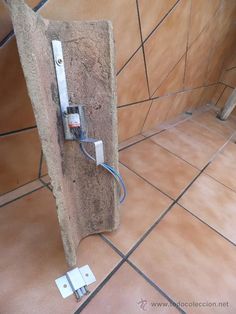 an electrical outlet in the corner of a room with tile flooring and wall tiles