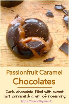 a chocolate covered donut sitting on top of a wooden table next to broken pieces of chocolate