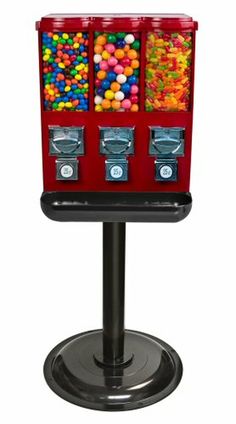 a red gummy machine sitting on top of a metal stand filled with lots of candy