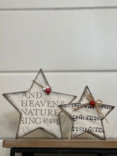 two wooden stars with musical notes on them sitting on a shelf next to each other