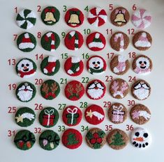 a number of christmas themed buttons on a white surface with red and green numbers in the middle