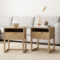 two side tables sitting next to each other on top of a carpeted living room floor