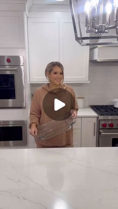 a woman standing in front of a kitchen counter