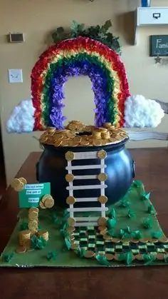 a pot full of gold coins sitting on top of a table next to a rainbow decoration